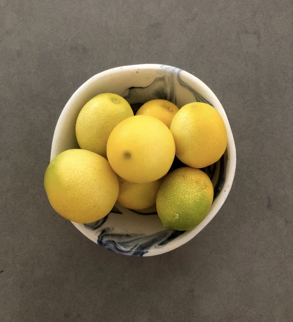 A ceramic bowl of fresh limes